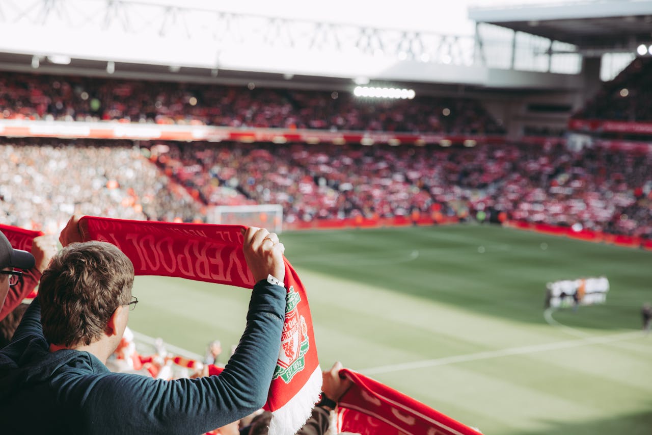 services-01 Passionate soccer supporters with scarves in Anfield Stadium, capturing the thrill of the game.
