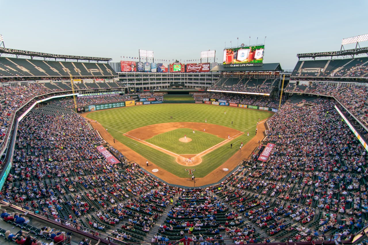 team-02 Aerial view of a lively baseball game at the iconic Globe Life Park filled with cheering fans.